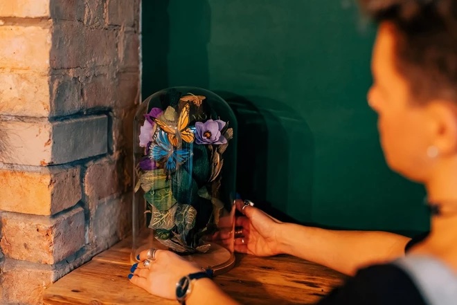 Papercraft butterflies displayed in a bell jar